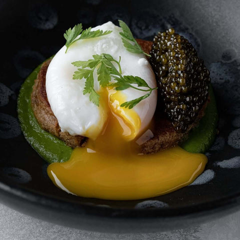 Fresh Kaluga Amur Caviar displayed on a sophisticated black dish